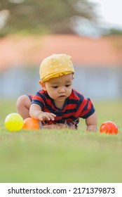 Asian Children Playing Ball In The Middle Of The Lawn