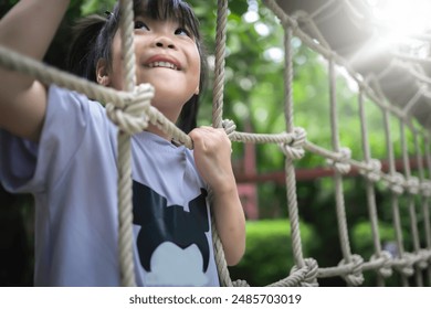 Asian children playing climbing rope net in playground - Powered by Shutterstock