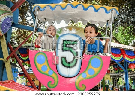 Asian children are playing on the playground while riding the Ferris wheel and helicopter for children