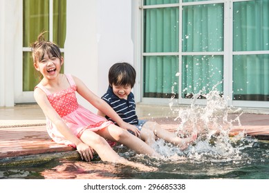 Asian Children Splashing Around In The Pool