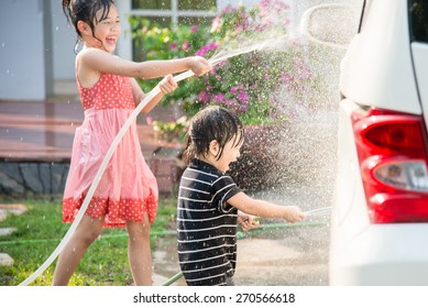 Asian children washing car in the garden - Powered by Shutterstock