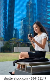 Asian Chinese Businesswoman Office Worker Communicating With Mobile Phone On Coffee Break Outdoors