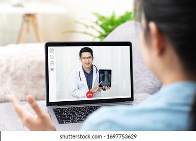 Asian Chinese Doctor Video Conference Call Online Talking For Follow Up Remotely With Medical Coronavirus Result At Home. Online Healthcare Digital Technology Service, Counselor And Internet Support.