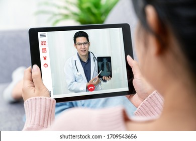 Asian chinese doctor video conference call online live talk follow up remotely in medical coronavirus result with asia woman sit at sofa couch at home. Online healthcare digital tech service concept.