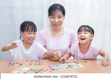 Asian Chinese Family Playing With Colorful Wooden Alphabet Toys At Home