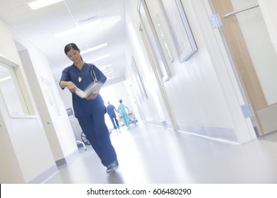 Asian Chinese Female Medical Nursing Staff In Scrubs In Corridor Of Modern Healthcare Facility Motion Blur