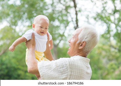 Asian Chinese Grandpa And Grandson Having Fun At Outdoor Garden.