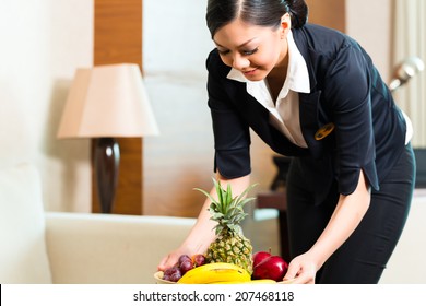 Asian Chinese Hotel Executive Housekeeper Placing Fruit Treatment To Welcome Arriving VIP Guests 