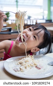 Asian Chinese Little Girl Eating Spaghetti At Outdoor Cafe