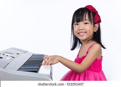 Asian Chinese Little Girl Playing Electric Piano Keyboard In Isolated White Background.