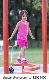 Asian Chinese Little Girl Walking On The Balance Beam At Outdoor Playground