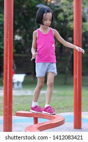 Asian Chinese Little Girl Walking On The Balance Beam At Outdoor Playground