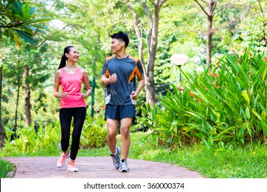 Asian Chinese Man And Woman Jogging In City Park