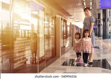 Asian Chinese Mother And Daughters Waiting For Transit At MRT Station In Kuala Lumpur, Malaysia.