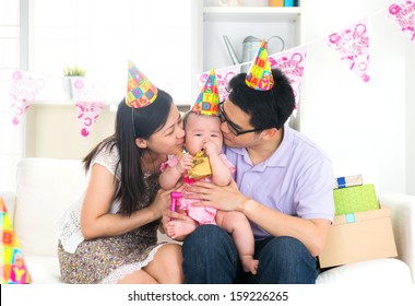 Asian Chinese Parent Kissing Baby On Birthday Party