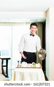 Asian Chinese Room Service Waiter Or Steward Serving Guests Food In A Grand Or Luxury Hotel Room 