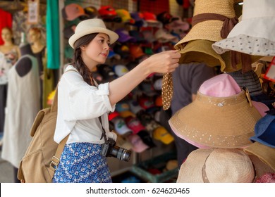 Asian Chinese Traveler Tourist Shopping Walking On The Famous Local Street Market Looking For Beautiful Weave Cap For Friends Or Family In The Hong Kong Vacation.