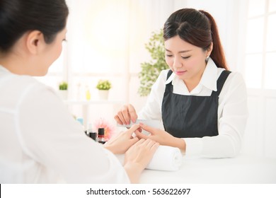 Asian Chinese Women Hands Receiving A Manicure In Beauty Salon. Nail Filing Close Up Selective Focus. Real Salon Spa Background. Beauty And Fashion Concept.