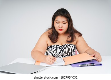 Asian Chubby Woman Working With Papers At Desk On White Background. 