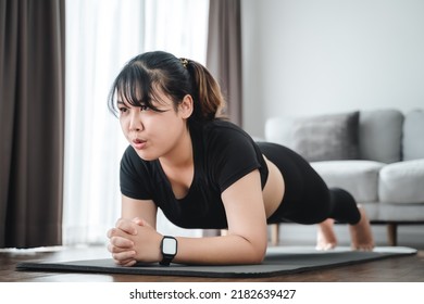 Asian Chubby Young Woman Doing Planking Exercise Indoors At Home .
