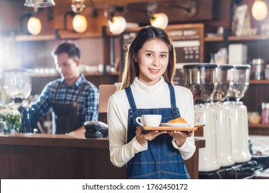 Asian Coffee Shop Owner Serving Bakery Cake And Coffee Cup To Customer In Coffee Shop, Small Business Owner And Startup In Coffee Shop And Restauran, Waitress And Barista Concept