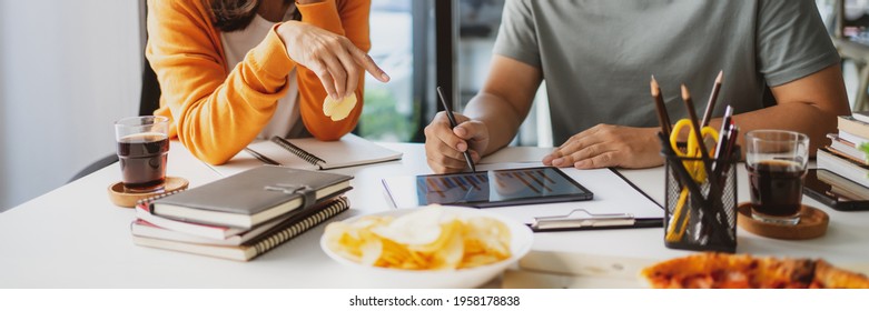 Asian College Friends Doing Projects And Eating Pizza , Chips In Breaking Time.