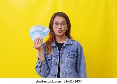 Asian College Student Standing While Holding An Indonesian Money. Allowance Or Scholarship Concept