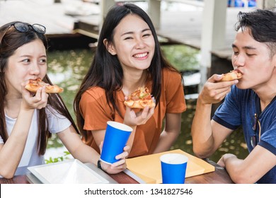 Asian College Or University Students Friends Teen Group Lifestyle Woman And Man Have Lunch Time Eating Pizza Together With Cheese, Fun And Enjoy Party Together At Outdoor University, Education Concept