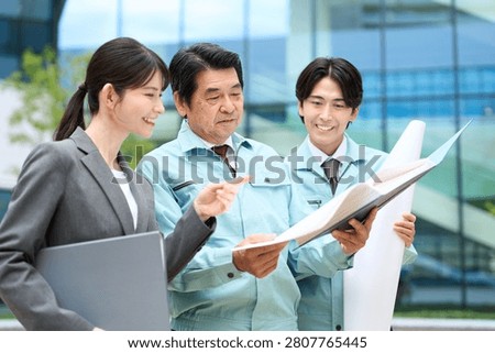 An Asian construction professional checking the blueprints.