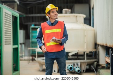 Asian Construction Site Manager Standing Wearing Safety Vest And Helmet, Thinking At Construction Site. Portrait Of Indonesian Manual Worker Or Architect With Satisfaction.