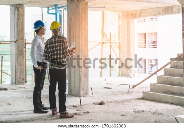 Asian contractor and engineer inspecting
material in construction
building.