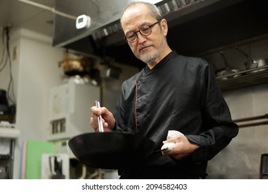 Asian cook cooking in a restaurant - Powered by Shutterstock