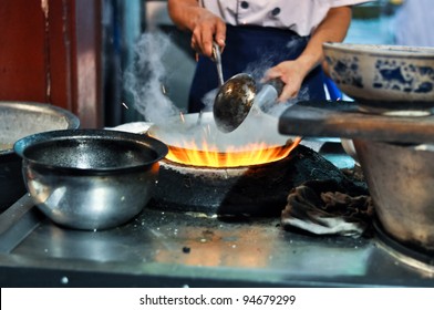 Asian Cook Cooking With A Wok On A Gas Flame