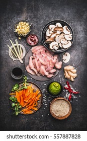 Asian Cooking Ingredients For Chicken Rice Dish With Vegetables On Dark Rustic Background , Top View, Flat Lay