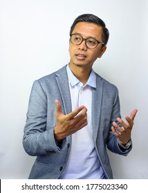 Asian Cool Young Man In A Casual Gray Blazer And Using Eyeglasses Is Explaining Or Presentation About Something, Isolated On White