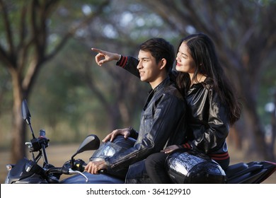 asian couple biker riding motorcycle woman pointing to ahead