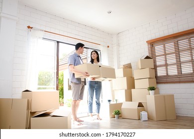 Asian Couple Buy A New House, Hold A Paper Box To Put Things In. Move Into A New House. Concept Of Starting A New Life, Creating A Family. Copy Space