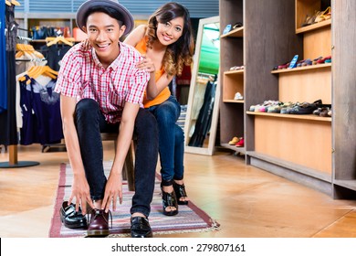 Asian Couple Buying Shoes In Store Or Shop