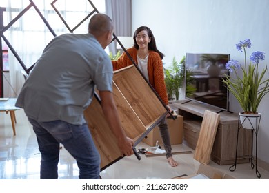 Asian Couple Carry New Furniture As They Move