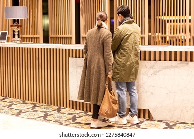 Asian Couple Checking In The Hotel At Hotel Reception.