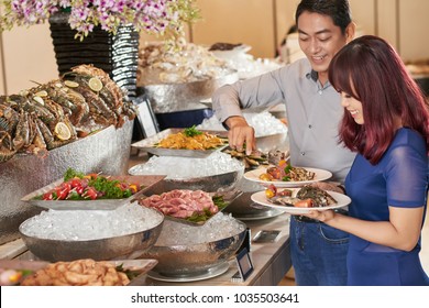 Asian Couple Chosing Appetizers Form Buffet Table