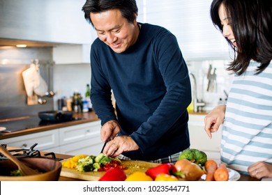 Asian Couple Cooking In The Kitchen