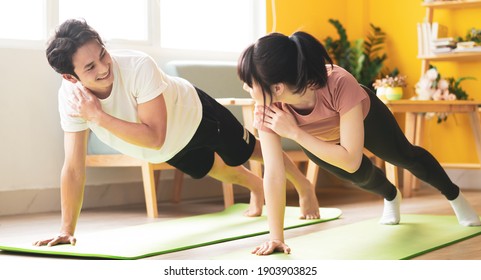 Asian Couple Doing Exercise Together At Home

