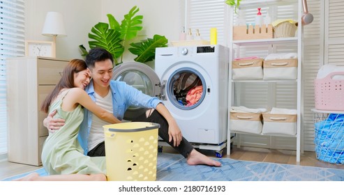 Asian Couple Doing Laundry Together And They Are Cuddling