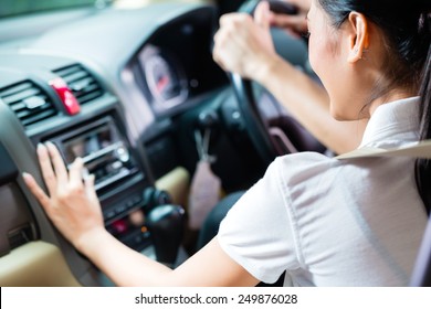 Asian Couple Driving New Car, She Is Turning On The Radio