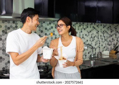 Asian Couple Eating Instant Noodles Together In The Kitchen.Enjoy For Meal Healthy.Lifestyle For Dinner And Stay At Home. Woman Eatting Instant Noodles.