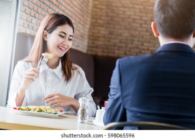 Asian Couple Eating And Laugh With Love Together At Restaurant