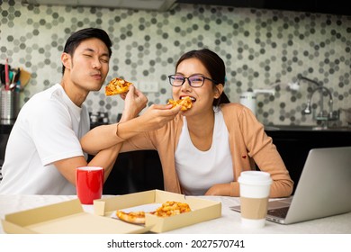 Asian Couple Eating Pizza Together In The Kitchen.Enjoy For Meal Healthy.Lifestyle For Dinner And Stay At Home. Woman Eatting Instant Noodles.