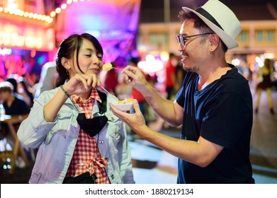 Asian Couple Enjoy Eating On The Street Food At Khao San Road