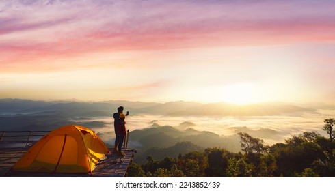 Asian couple enjoy in they tent at they camping point with morning sunrise view, fog and mountain view, land scape of Doi mon kalakojo at Tak near Chiang mai, Thailand